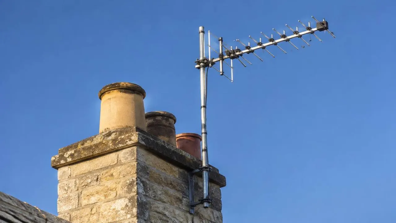 Modern TV aerial on a Cotswold stone chimney